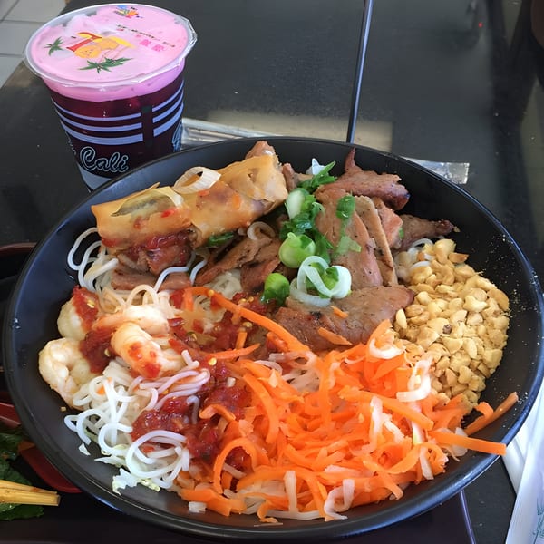 BMC Pho's vermicelli bowl with shrimp, pork, egg roll, and a pink drink.